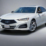 White Acura car parked in a lot with other vehicles