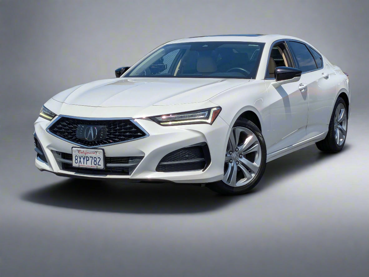 White Acura car parked in a lot with other vehicles