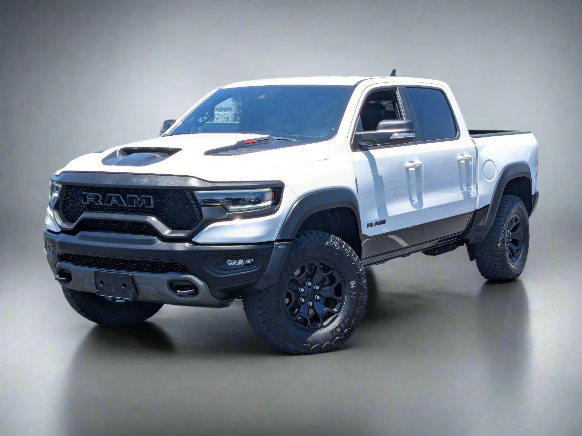 White Ram truck parked in a lot with trees and buildings in the background