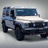 White off-road vehicle in a parking lot with palm trees in the background